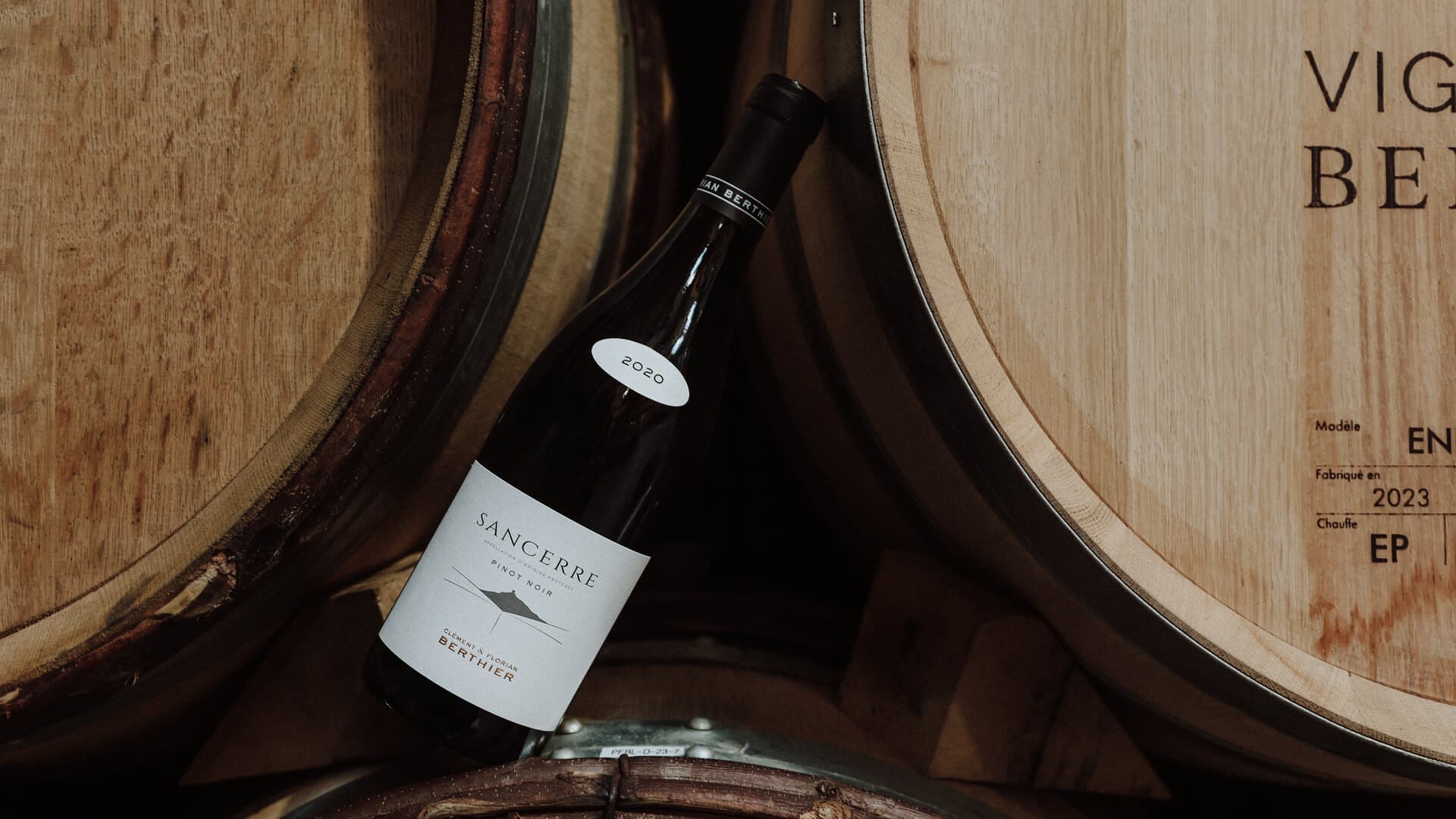 Une bouteille de vin de Sancerre rouge au milieu des tonneaux